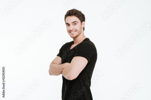 Happy young man standing with arms crossed
