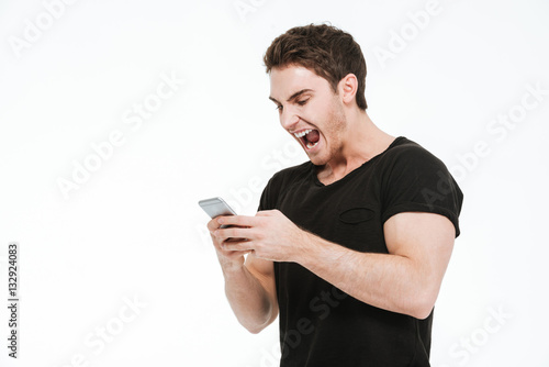 Angry screaming young man using phone.