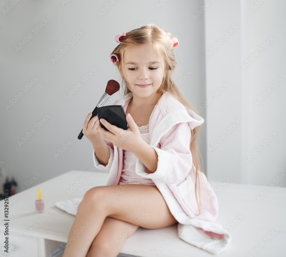 Little girl with long blond hair and brown eyes, wind the hair on the