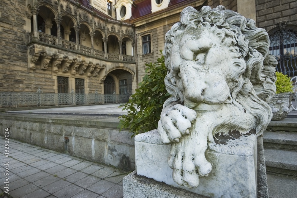 Obraz premium Stone statue of lion in entrance portal of the old castle in Moszna, near Opole, Silesia, Poland