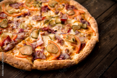 delicious pizza on thin crust with chicken  cheese  pickles and peppers