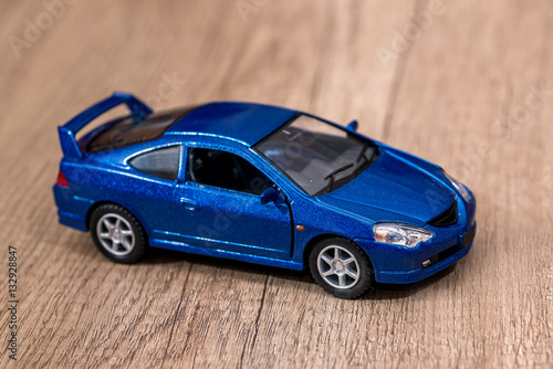 Classic blue model toy car on wooden desk.