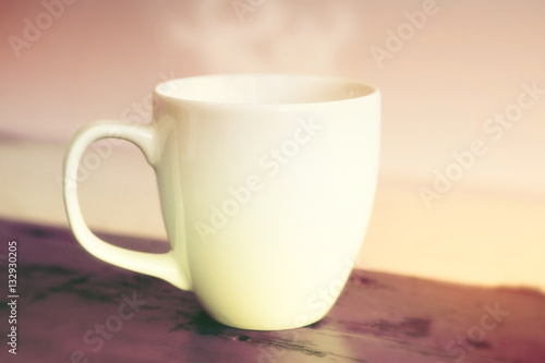 white steamy cup on red wooden table