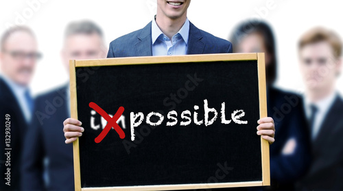 businessman holding a sign with the word Possible