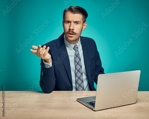 Sad Young Man Working On Laptop At Desk