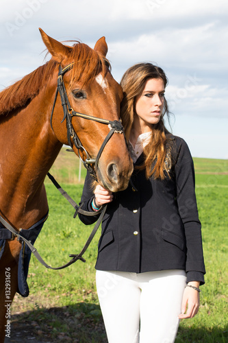 Beautiful girl with her horse dressing uniform competition: outdoors portrait on sunny day