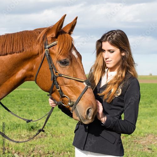 Beautiful young girl in uniform competition hugs her horse : outdoors portrait on sunny day © gg333