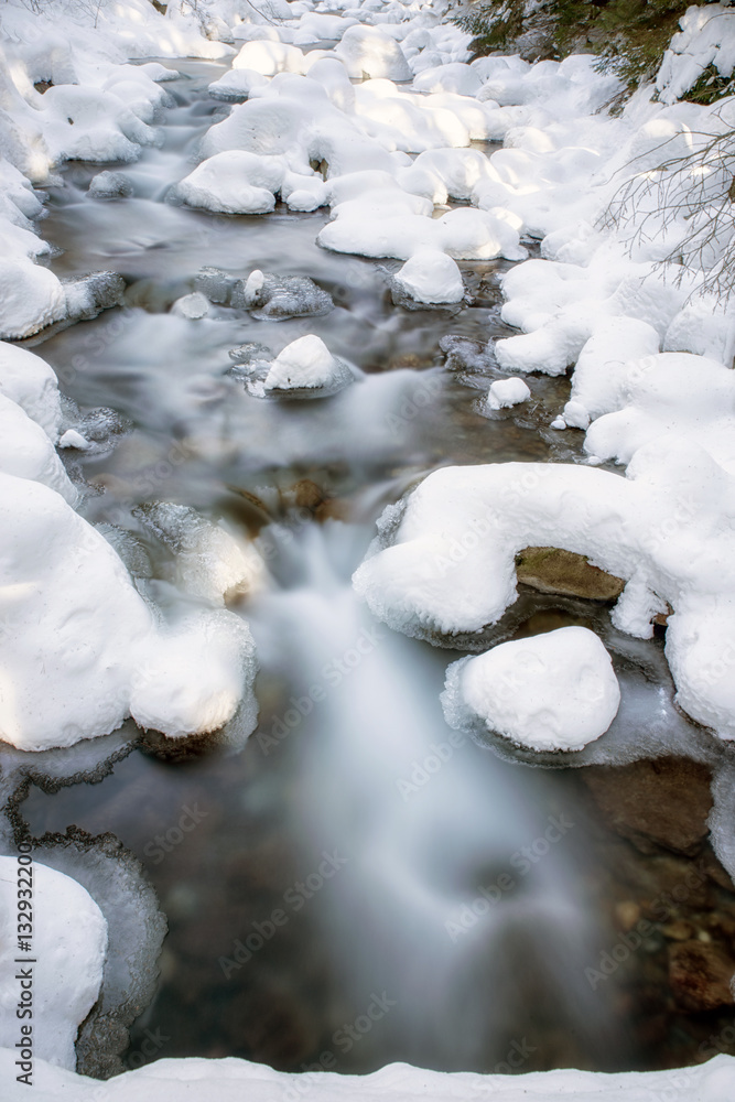 Long exposure of river in winter forest at Jalovecka valley, Slovakia