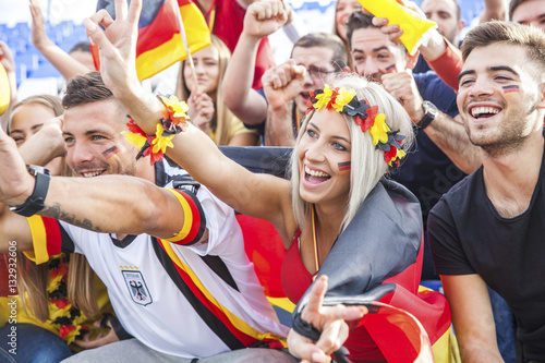 German soccer fans in stadium cheering