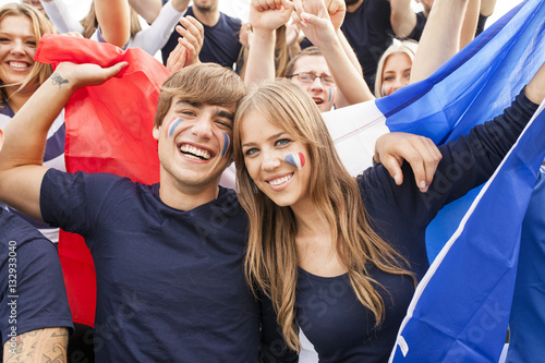 Group of soccer fans celebrating with French flag photo