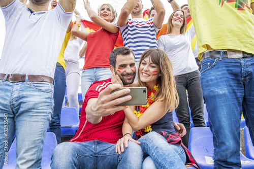 Soccer fans taking a selfie in stadium