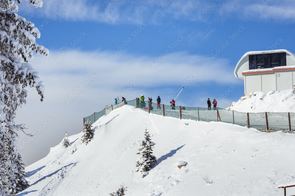 Fototapeta premium People skiing on the ski slope covered with snow in the winter season in the mountain resort of Poiana Brasov, Romania