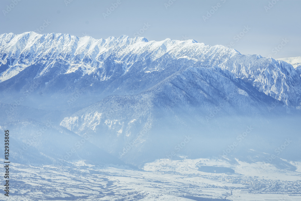 Winter landscape over the Piatra Craiului Mountains in Brasov county, Romania.View of the Carpathian Mountains, Romania, in the winter season covered by snow