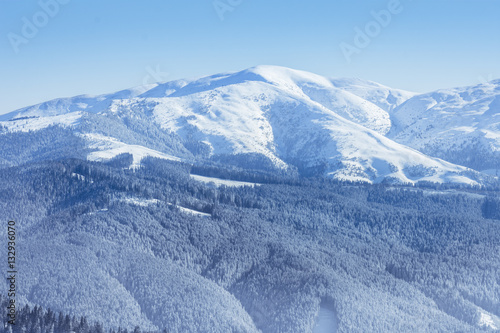 Winter landscape of the mountains and trees covered by snow in Brasov, Romania. View of the Romanian Carpathian Mountains and the forests in the winter season covered by snow © marios_b