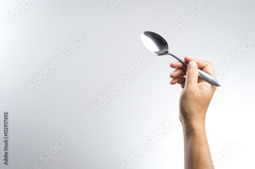 Man hand holding a silver spoon