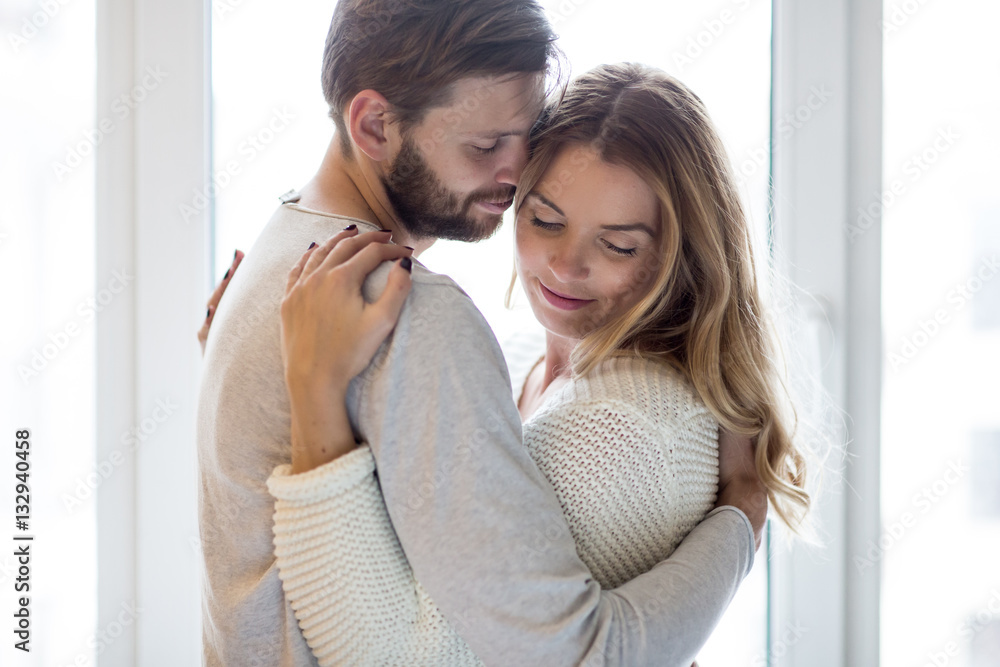 Embracing lovers near window Embracing lovers near window
