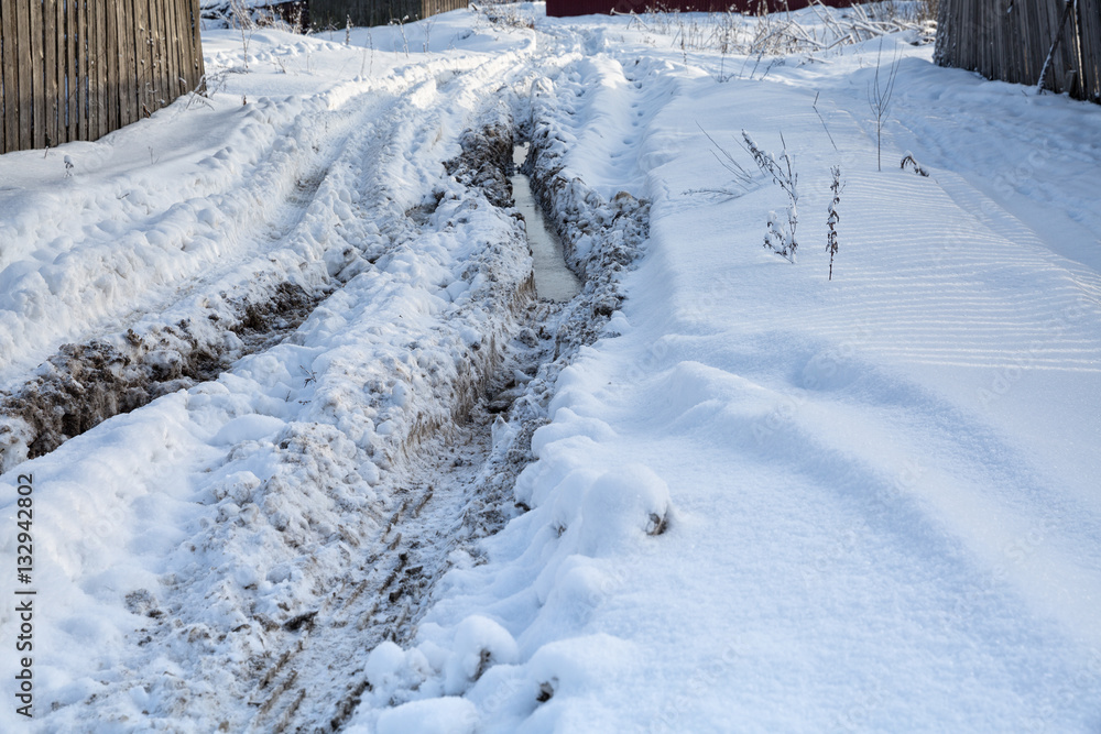 Rut with puddles. Traces of tractor tires in snow Rut with puddles. Traces of tractor tires in snow