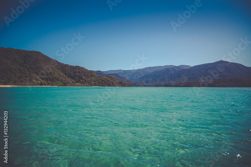 Beautiful dreamy ocean landscape with soft green hills of Abel Tasman National Park, New Zealand