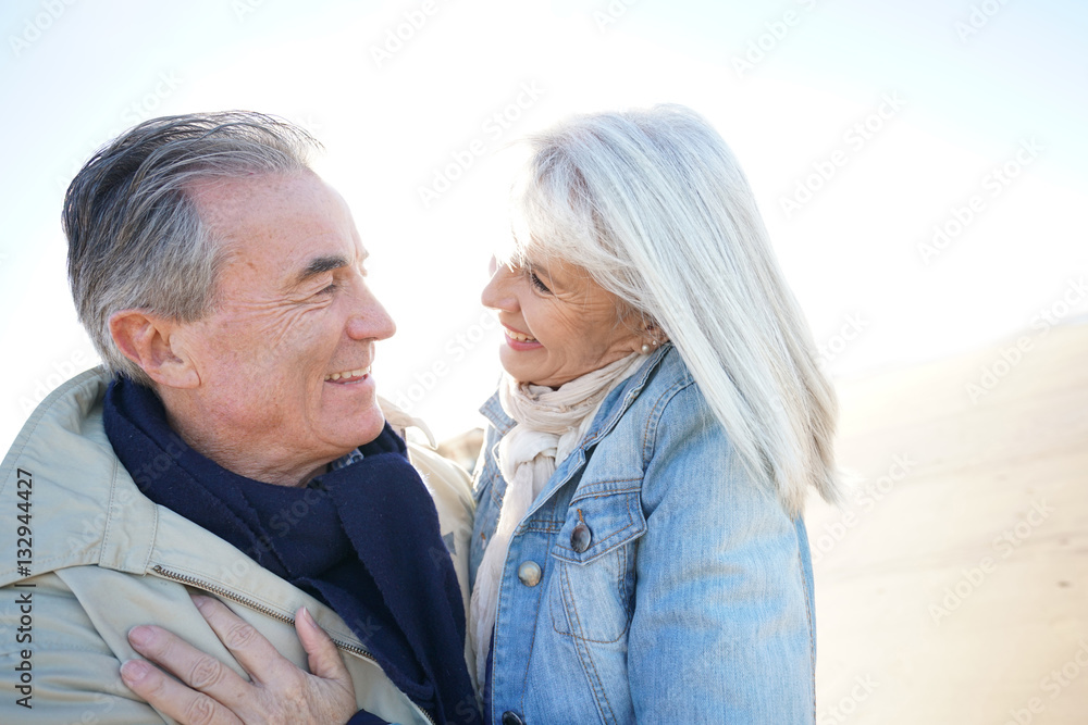 Portrait of senior couple having fun at the beach, wintertime Portrait of senior couple having fun at the beach, wintertime