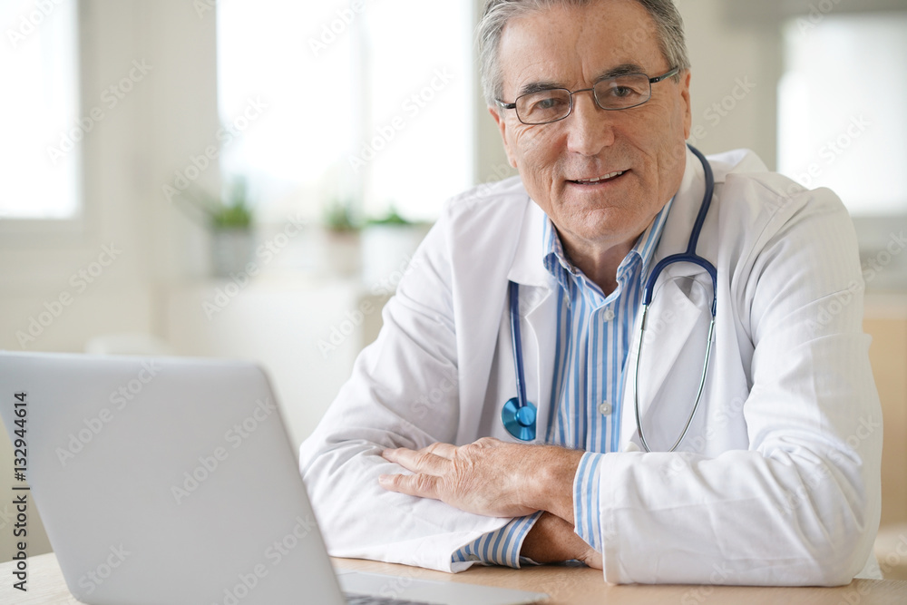 Portrait of senior doctor sitting in medical office Portrait of senior doctor sitting in medical office