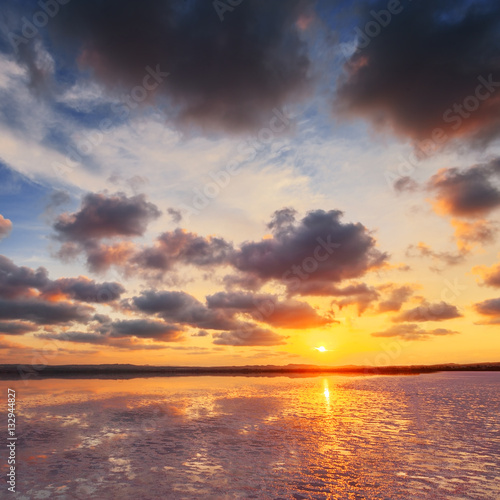 Sunset sky with clouds above salt lake. Beautiful sunny landscape. © Maxim Khytra