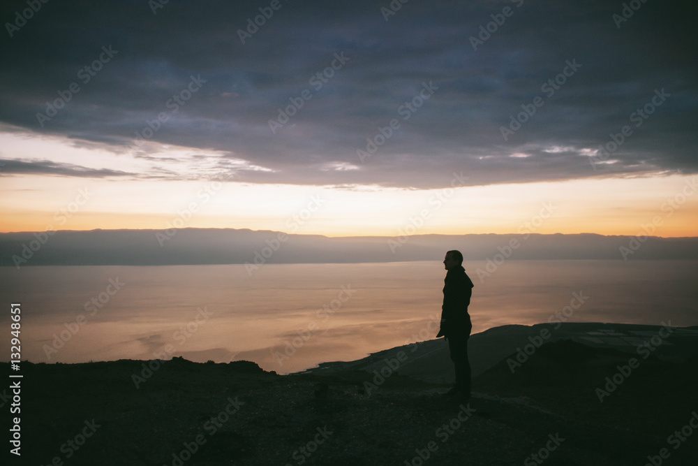 Sunrise in the mountains with a beautiful view of the sea and rocks and a lonely person watching it