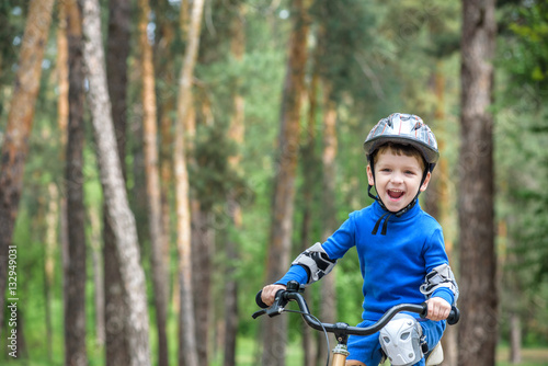 Little kid boy of 3 years and his father in autumn forest with a bicycle. Dad teaching son. Man happy about success. Child helmet. Safety, sports, leisure kids concept