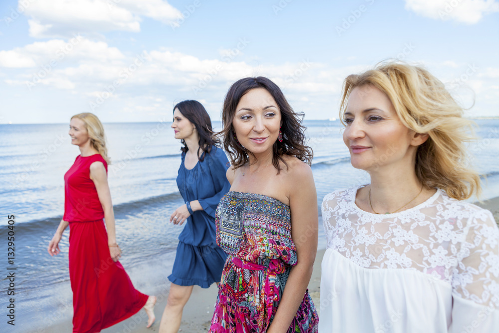 Group of women take a walk along the beach Group of women take a walk along the beach