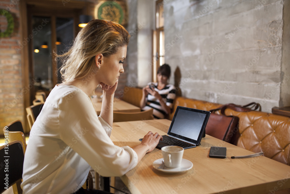 Woman in coffee shop using digital tablet Woman in coffee shop using digital tablet