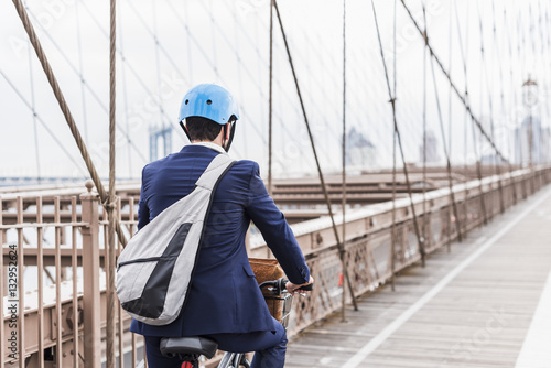 USA, New York City, man on bicycle on Brooklyn Bridge photo