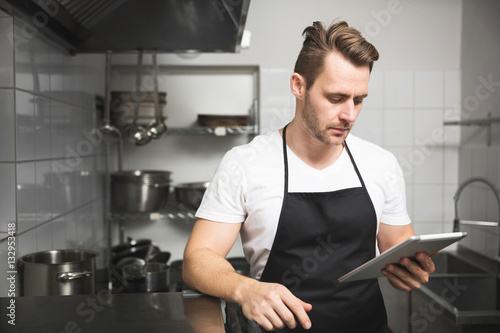 Chef in the kitchen reading on tablet