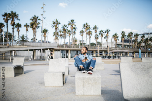 Spain, Barcelona, young man relaxing on beach promenade