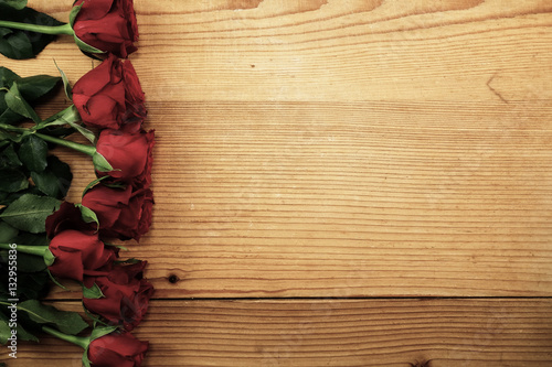 Red roses on the textured wood with copy space
