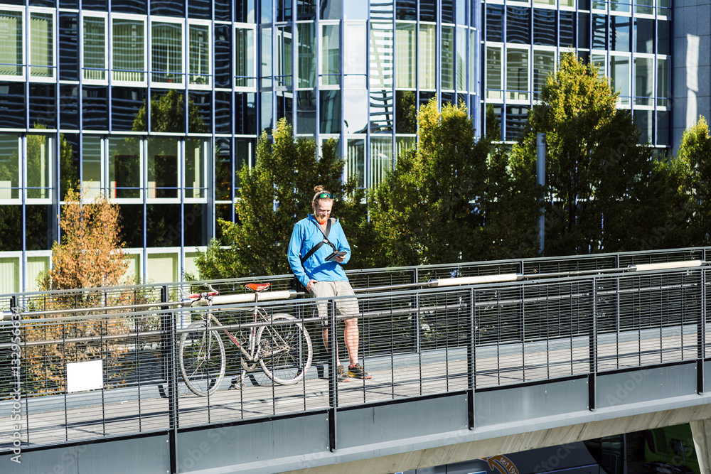 Bike messenger resting on footbridge Bike messenger resting on footbridge