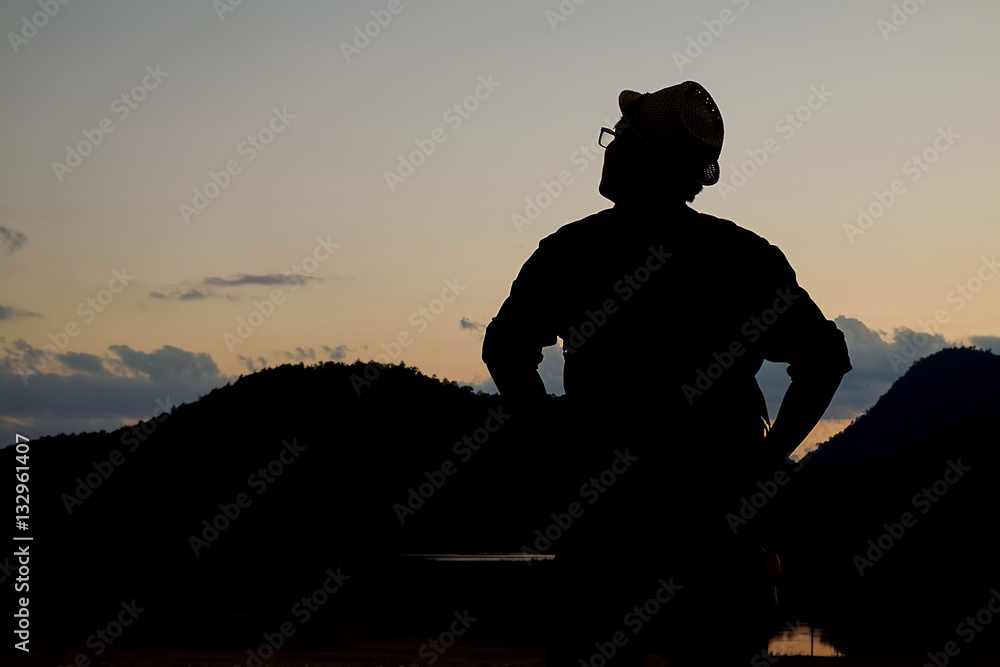 Silhouette Asian hipster man enjoying sunset on peak. Tourist traveler on background valley landscape view mock-up, sunset in trip in basque country.