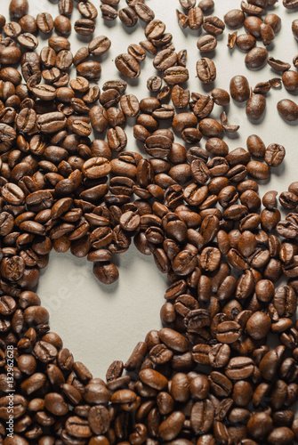 Coffebeans on Neutral Gray Background. Dark Roast Coffee. Heart.