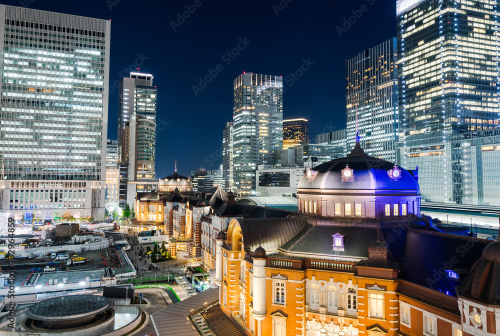Asia Business concept for real estate and corporate construction - panoramic modern cityscape building bird eye aerial night view of Tokyo Station under neon light and dark blue sky in Tokyo, Japan