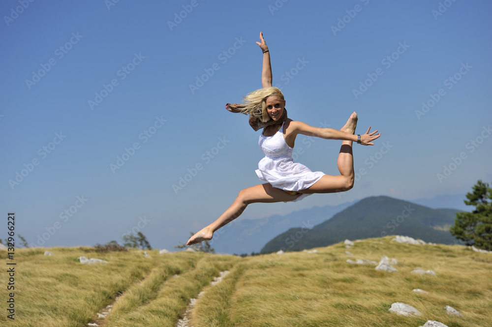 Beautiful women in white dress jumping in attractive dance position. (she was jumping on trampoline) Beautiful women in white dress jumping in attractive dance position. (she was jumping on trampoline)