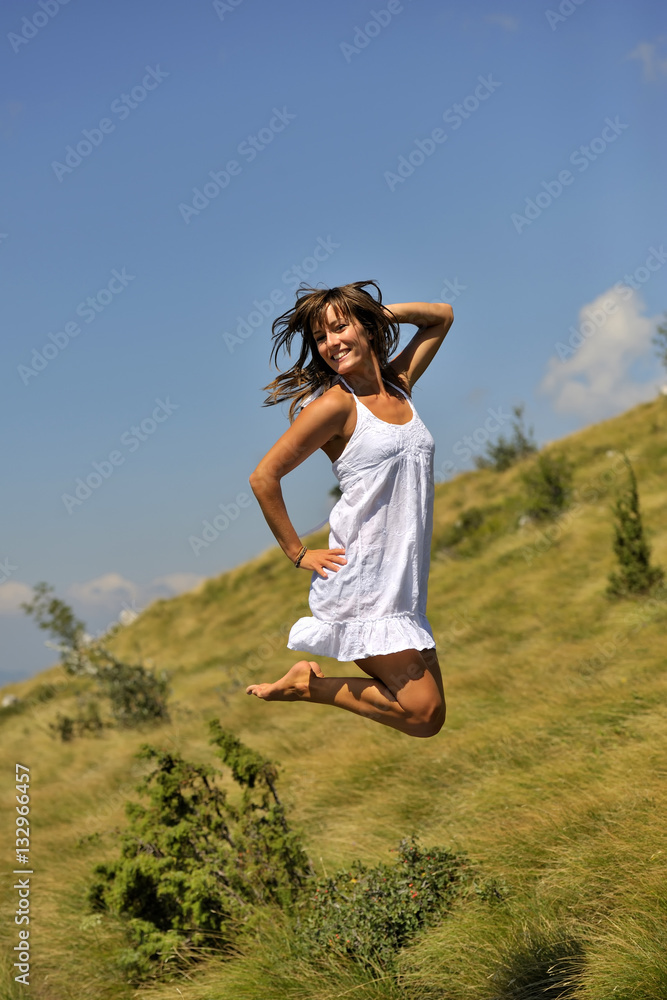 Young woman in white dress jumping in cute pose. she was jumping on  trampoline Stock-Foto | Adobe Stock
