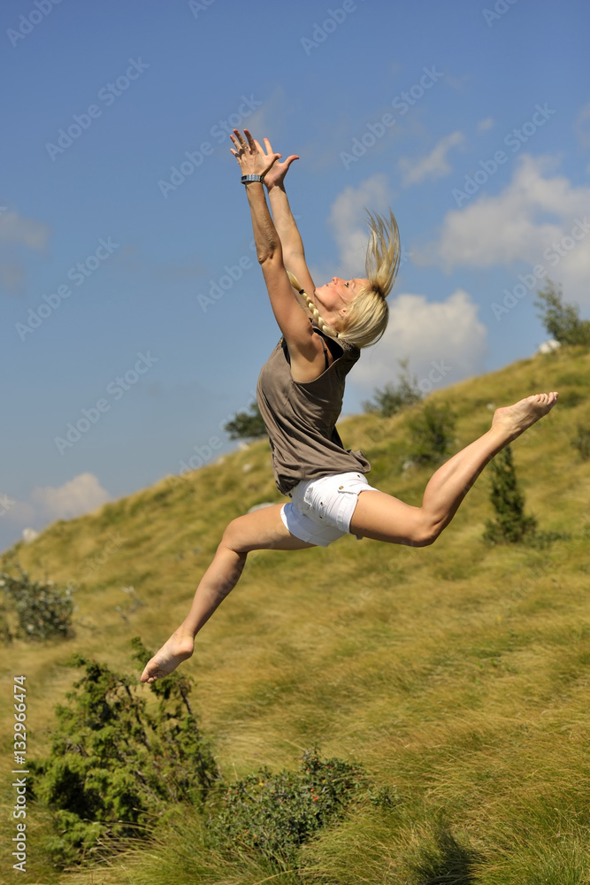 Holding the sun. Beautiful, fit women in nice dancing position express her feelings. (she was jumping on trampoline) Holding the sun. Beautiful, fit women in nice dancing position express her feelings. (she was jumping on trampoline)