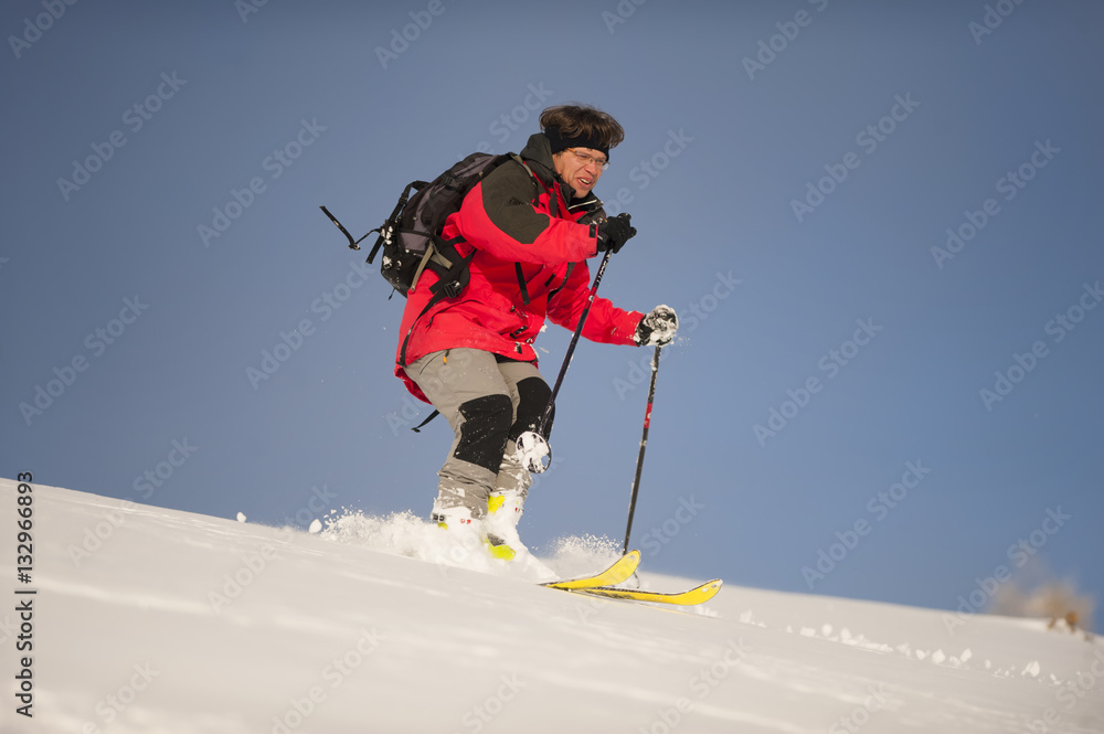 Alpine skier. Mid adult man skiing down steep hill in nature.
