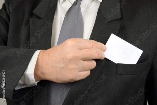 Homme d'affaires sortant une carte de sa veste 