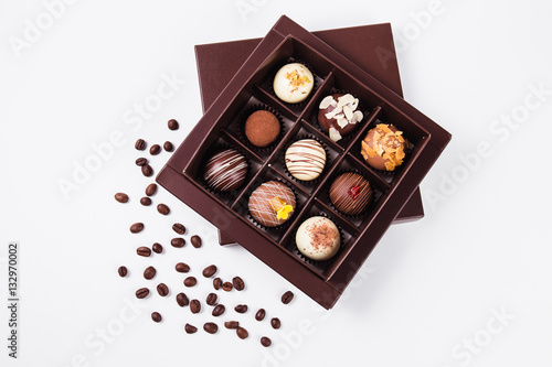 handmade chocolates in a square box and coffee beans near