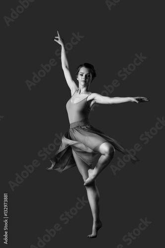 girl dancing barefoot. ballet. grey background 