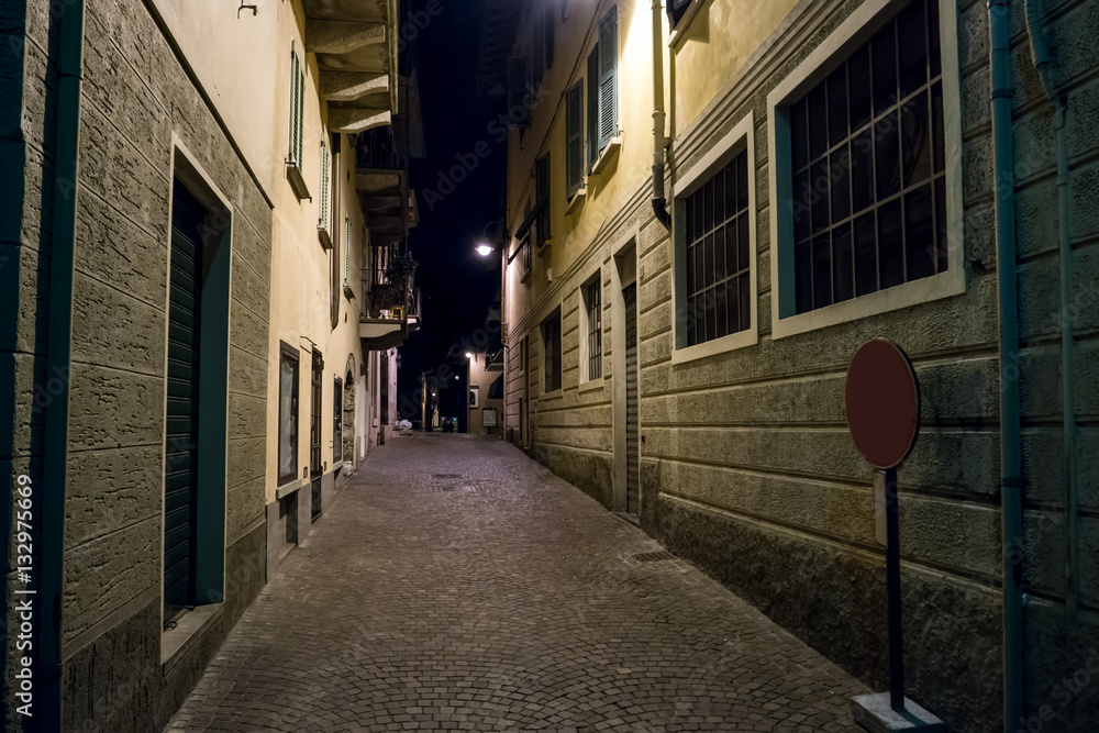 Narrow street during night. Town buildings and dark sky. Get lost in the streets.