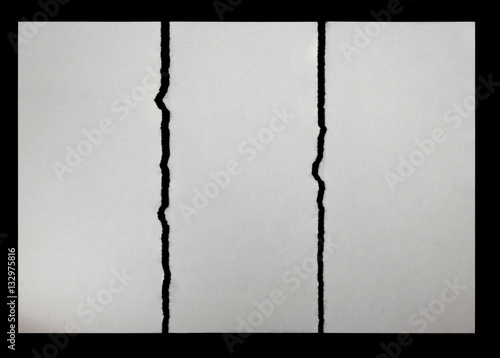 three pieces of torn paper on a black background