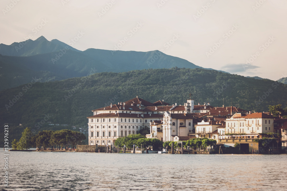 Town buildings near water. Mountains and sky. Landmarks on the island.