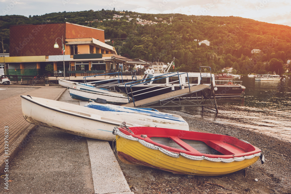 Boats on the shore. Buildings and trees on hill. Spend vacation in quiet town.