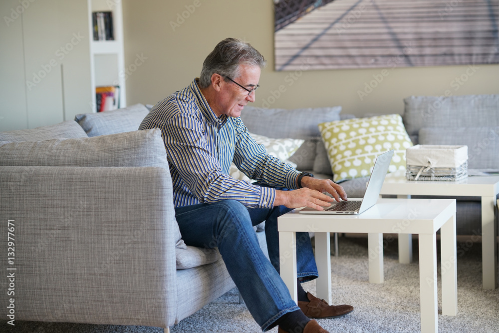 Senior man in living-room using laptop computer