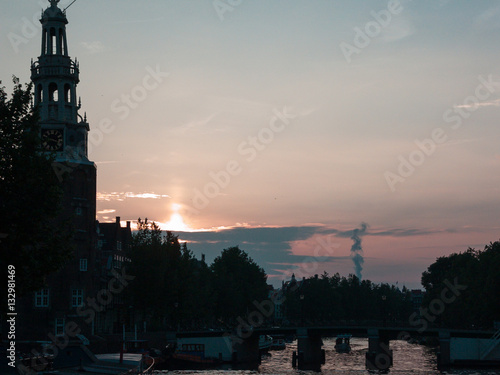 Silhouettes of a tower and House near an Amsterdam Canal.
